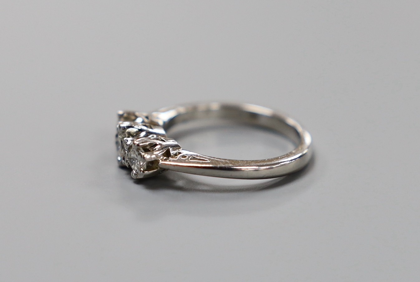 A modern platinum and three stone diamond ring, size H, gross weight 4.8 grams.